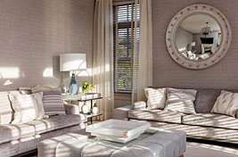 Custom upholstered Greenwich sofas with wood rail paired with a tufted ottoman table with inset tray designed by Bespoke by Luigi Gentile. Interiors: Penny Drue Baird/ Dessins LLC