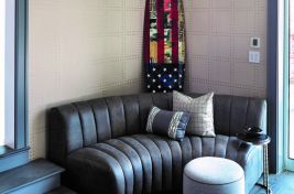 Custom curved channeled upholstered armless sofa in chic grey leather. \r\nDesigner: Robyn Karp Designs\r\nUpholstery: Bespoke by Luigi Gentile