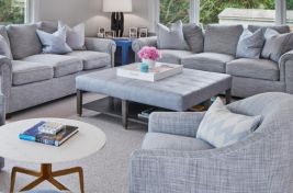 Close up of our custom State Ottoman with a lower storage shelf and blue leather upholstered top for Robyn Karp Designs. 